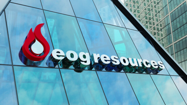 A glass building features the EOG Resources logo, which includes a red flame symbol next to the company name in white lowercase letters. Reflections of nearby skyscrapers are visible in the glass.